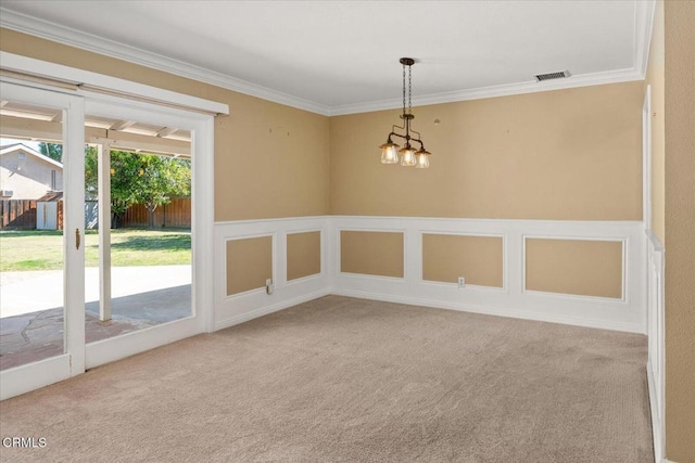 carpeted empty room featuring a wainscoted wall, ornamental molding, visible vents, and a decorative wall