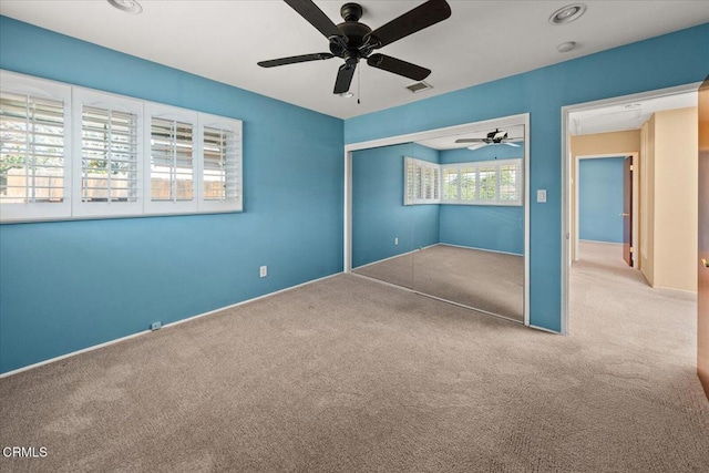 unfurnished bedroom with a ceiling fan, a closet, carpet flooring, and visible vents