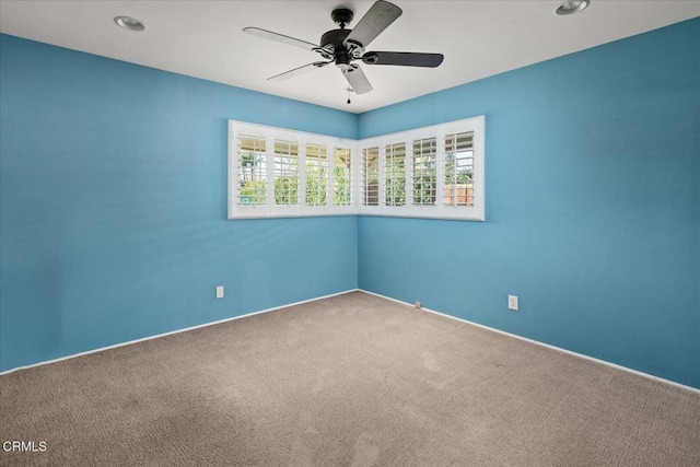 carpeted empty room with a ceiling fan