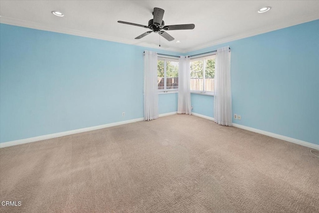 carpeted spare room featuring a ceiling fan, recessed lighting, crown molding, and baseboards