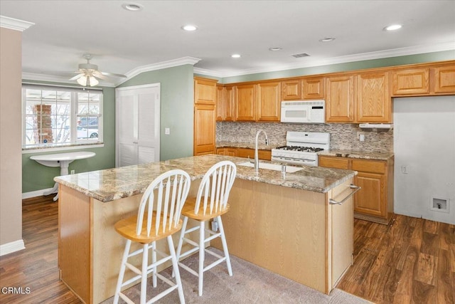 kitchen with white appliances, crown molding, dark wood finished floors, and a sink