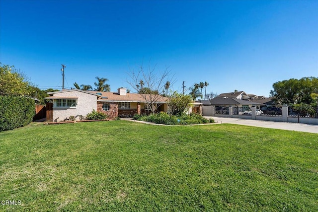 ranch-style home with driveway, a front lawn, and fence