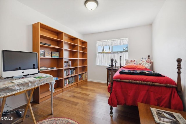 bedroom featuring baseboards and wood finished floors