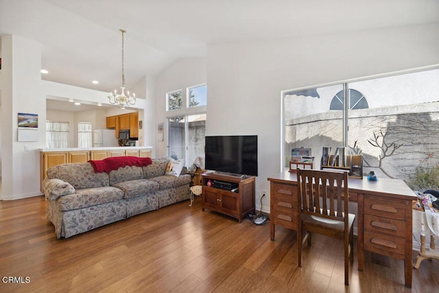 living area featuring light wood-style floors, a notable chandelier, high vaulted ceiling, and baseboards