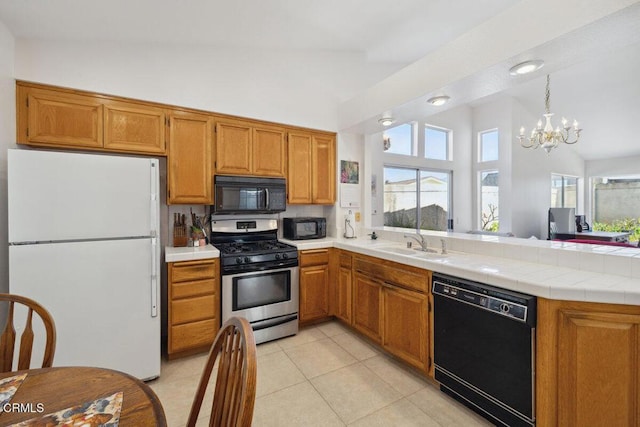 kitchen featuring a healthy amount of sunlight, a sink, a peninsula, and black appliances