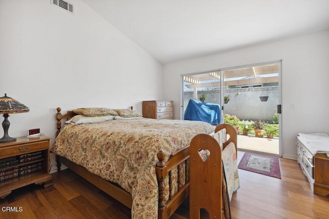 bedroom with access to outside, visible vents, lofted ceiling, and wood finished floors