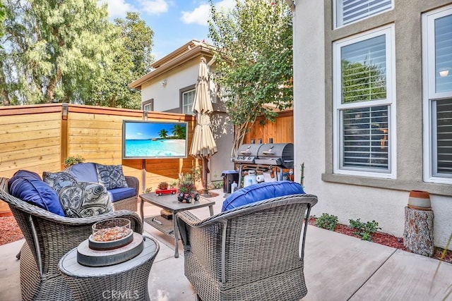 view of patio with an outdoor hangout area, area for grilling, and fence