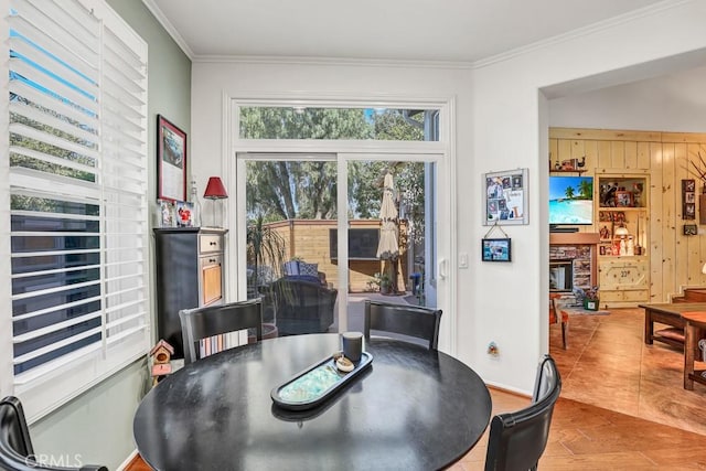 dining space featuring crown molding, a fireplace, and wood finished floors