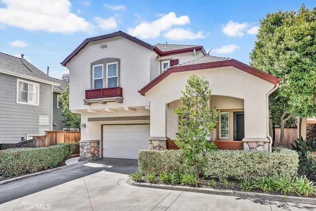 mediterranean / spanish house featuring driveway, fence, and stucco siding