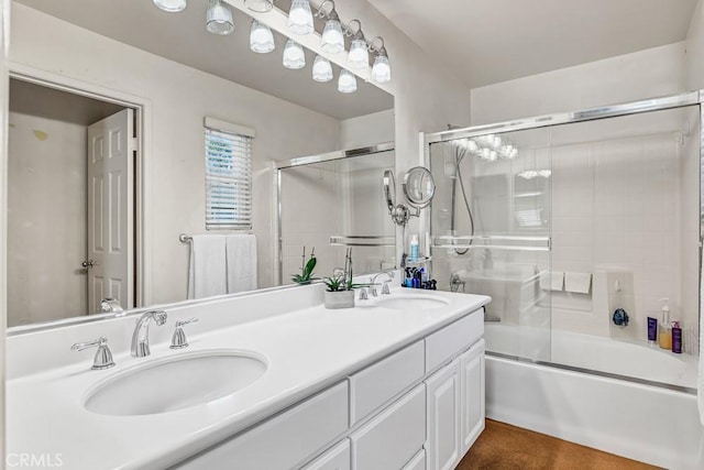 full bath with double vanity, combined bath / shower with glass door, and a sink