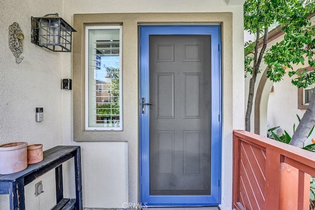 property entrance with stucco siding