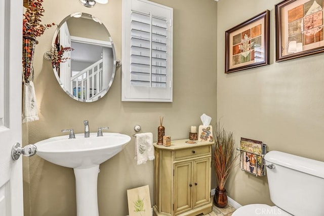 bathroom featuring toilet and baseboards