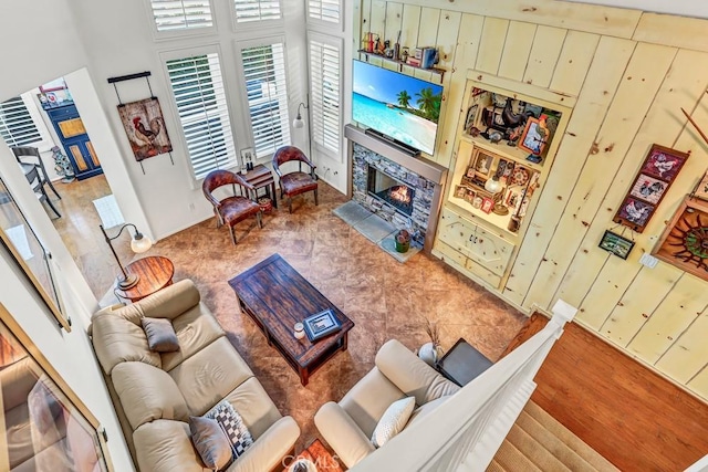 living area with a high end fireplace and wooden walls