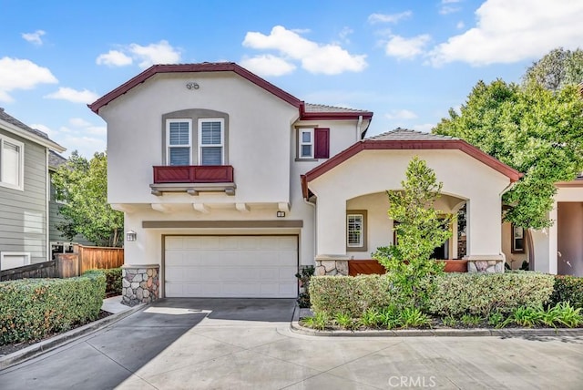 mediterranean / spanish home featuring a garage, driveway, fence, and stucco siding