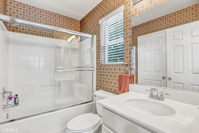 full bath with enclosed tub / shower combo, vanity, and toilet