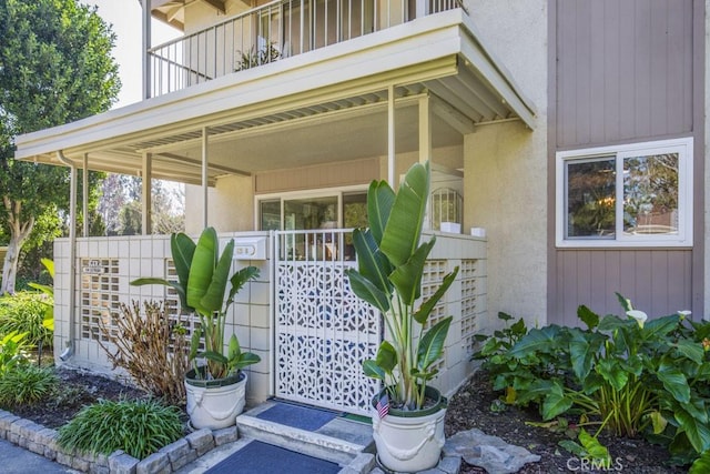 view of exterior entry with a balcony