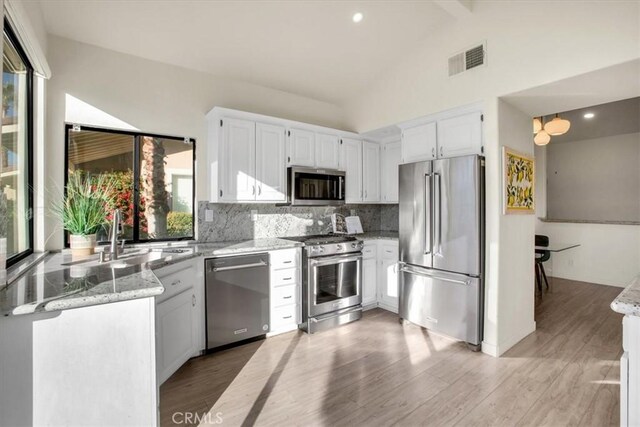 31 Blue River Dr, Palm Desert, CA 92211 - kitchen featuring high quality appliances, a sink, light stone counters, decorative backsplash, and recessed lighting