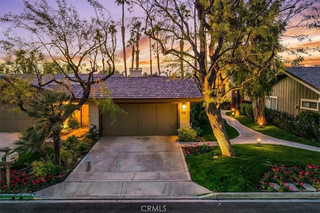 31 Blue River Dr, Palm Desert, CA 92211 - view of front of home with driveway, a chimney, a front yard, and stucco siding