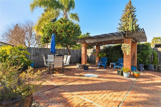 view of patio with outdoor dining space, a fenced backyard, and a pergola