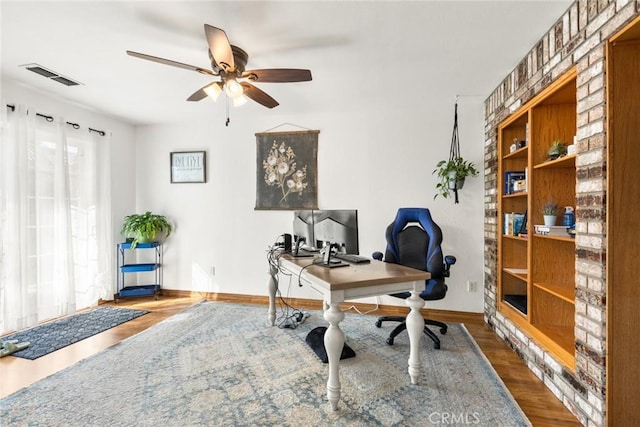 office featuring baseboards, visible vents, ceiling fan, and wood finished floors