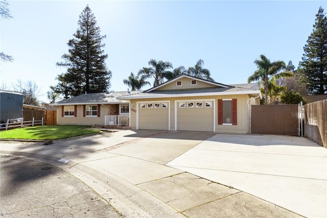 single story home with a front yard, concrete driveway, fence, and an attached garage