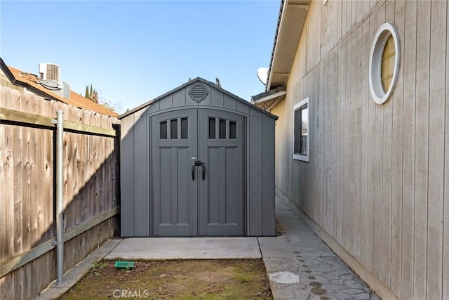 view of shed with central AC and fence