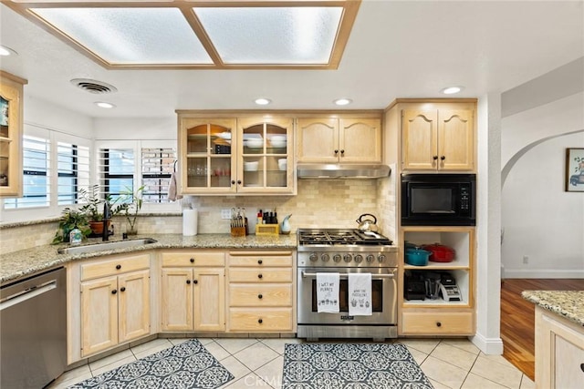 kitchen with stainless steel appliances, light brown cabinetry, a sink, and under cabinet range hood