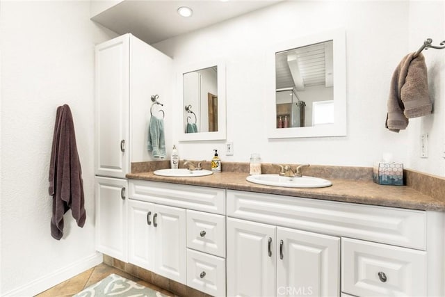 bathroom with double vanity, a sink, and tile patterned floors