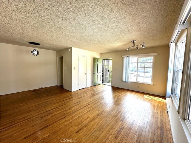 unfurnished room with a textured ceiling and light wood-style floors