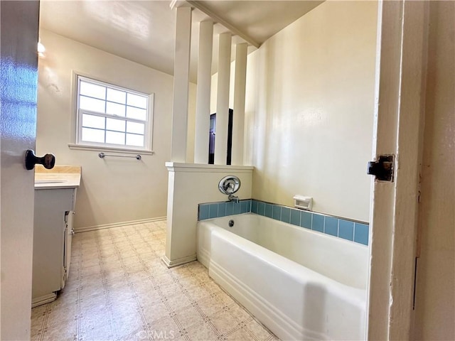 bathroom with vanity, baseboards, a bath, and tile patterned floors