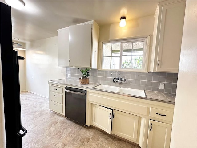 kitchen with dishwashing machine, tile counters, decorative backsplash, a sink, and baseboards