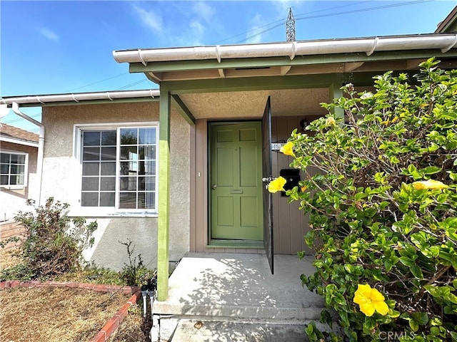 view of exterior entry with stucco siding