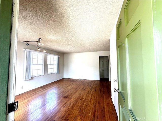 empty room featuring dark wood-style floors and a textured ceiling