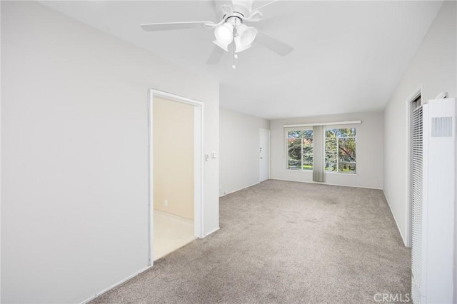 interior space featuring ceiling fan, carpet, and a heating unit