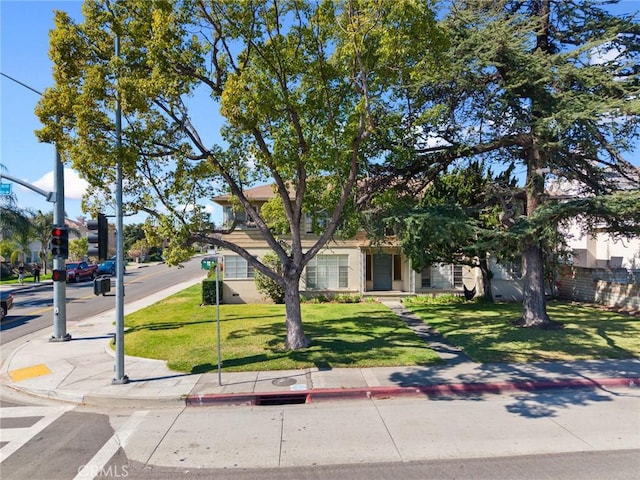 view of property hidden behind natural elements featuring a front yard