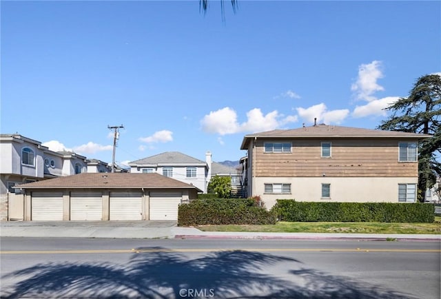 view of property exterior featuring an outbuilding and community garages