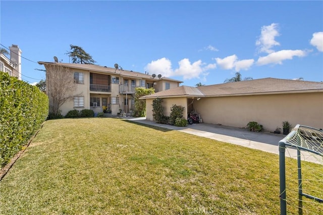 view of front facade with a patio area, fence, a front lawn, and stucco siding