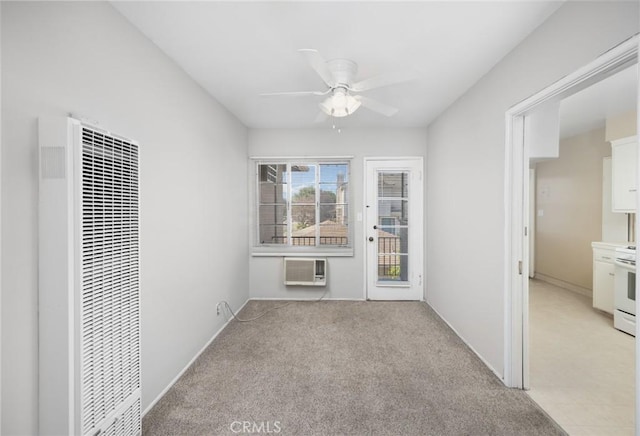 empty room featuring light colored carpet, a heating unit, ceiling fan, and a wall mounted AC