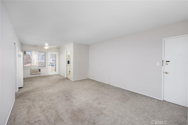 unfurnished living room featuring a ceiling fan, a wall mounted air conditioner, and light colored carpet