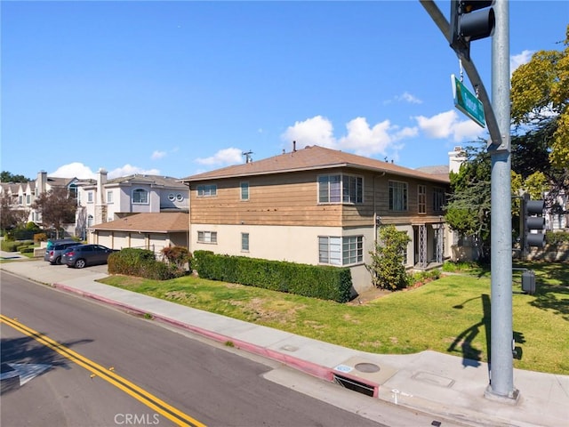 exterior space featuring a front yard, a residential view, and stucco siding