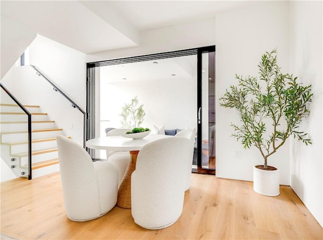 dining area featuring light wood-type flooring and stairway