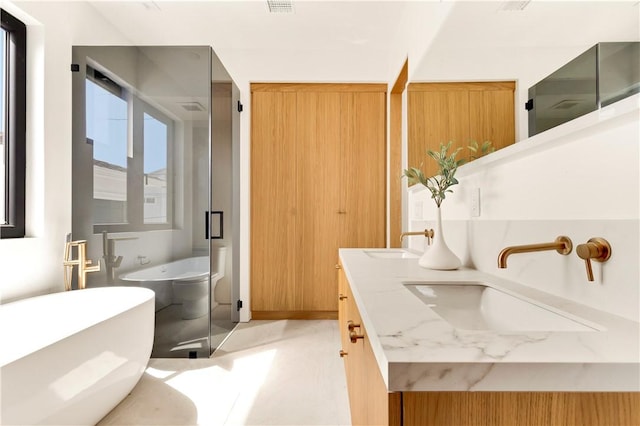 bathroom with a soaking tub, a sink, and double vanity