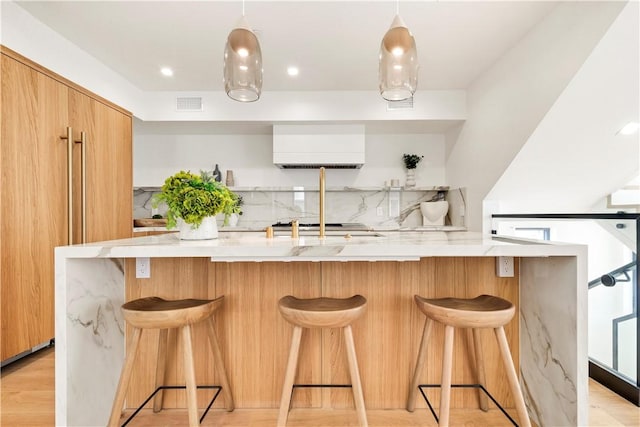 kitchen with light countertops, modern cabinets, backsplash, and visible vents