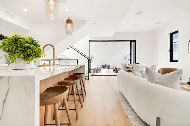 living room with light wood finished floors, visible vents, and recessed lighting