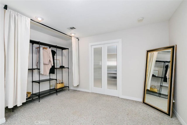 empty room with french doors, visible vents, and baseboards