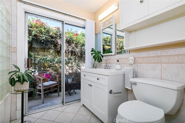 bathroom featuring toilet, vanity, tile walls, and tile patterned floors