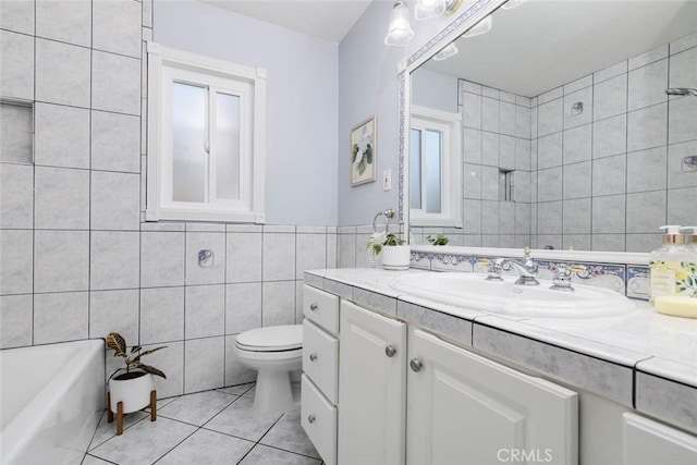 full bath with tile walls, toilet, a bathing tub, vanity, and tile patterned floors