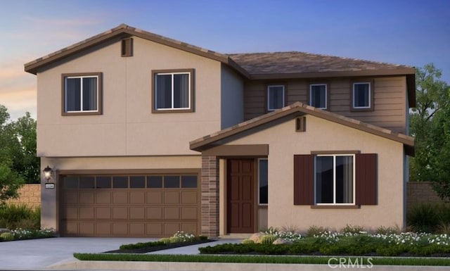 view of front facade featuring a garage, concrete driveway, and stucco siding