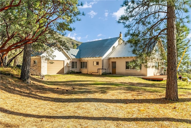 back of property featuring metal roof and a lawn