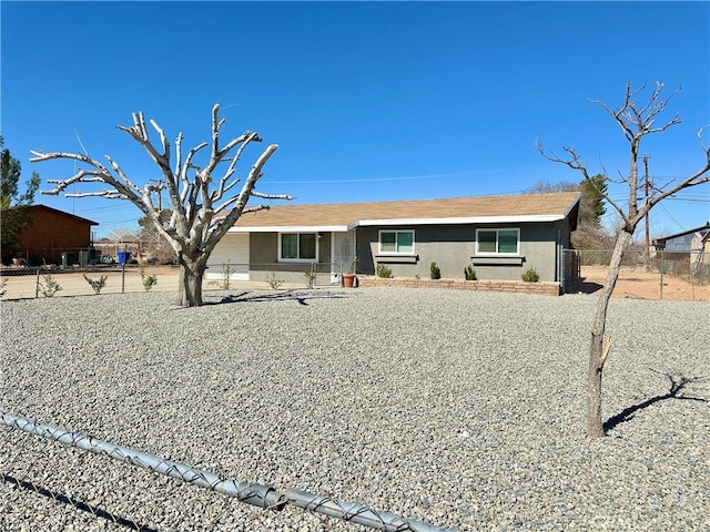 ranch-style home featuring fence and stucco siding